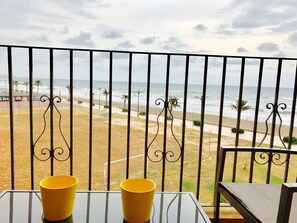 A balcony with a view of the beach, two yellow cups on a table, and a chair. - First line of the sea - Port Saplaya (Alboraia)