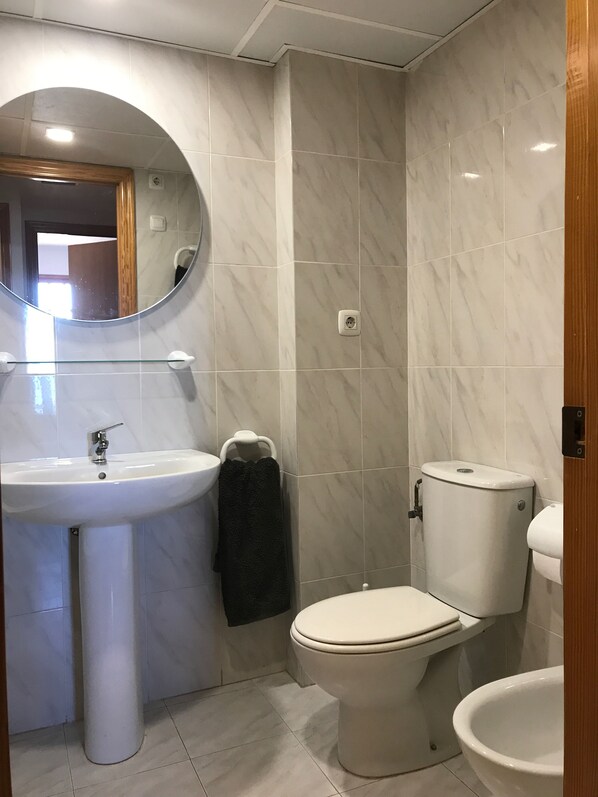 A bathroom with a pedestal sink, a toilet, and a bidet. - First line of the sea - Port Saplaya (Alboraia)