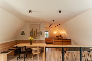 Een moderne keuken met houten kasten, een zithoek met een bank en stoelen, en hanglampen.