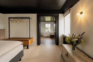 Un dormitorio moderno con una cama de madera, una mesita de noche y un perchero.