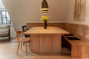 Una cocina moderna con una isla de madera, una banqueta y un jarrón con flores.