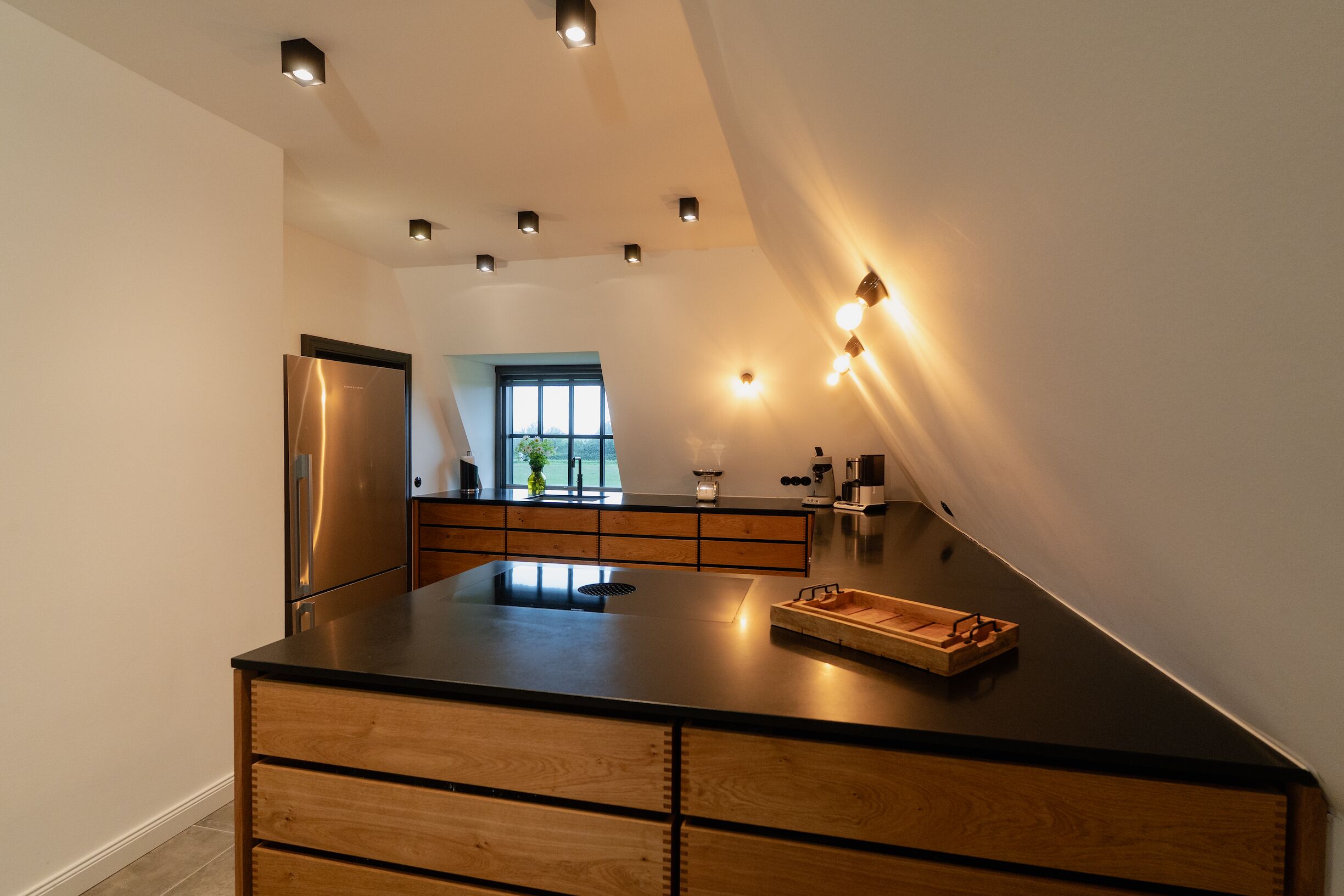 A modern kitchen with a central island, built-in appliances, and a view to the outdoors.