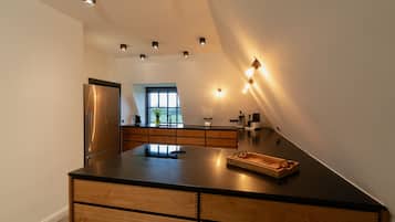 A modern kitchen with a central island, built-in appliances, and a view to the outdoors.