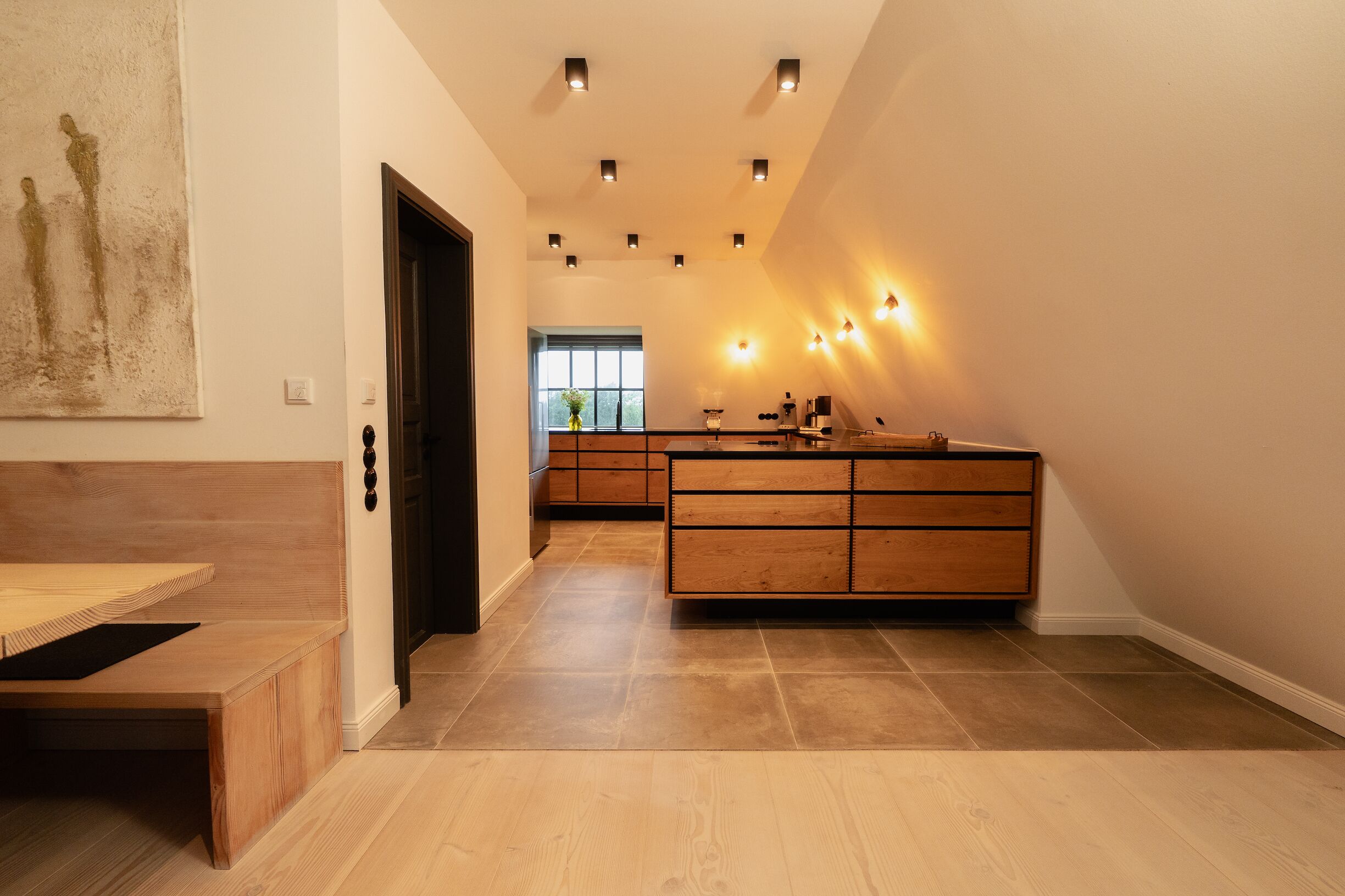 A modern kitchen with a wooden island, recessed lighting, and a view to the dining area.