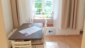 Ein Essbereich mit Tisch, Stühlen, einer Karte und einem Fenster mit Vorhängen.