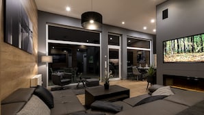 A modern living room with a sectional sofa, a flat-screen TV, and a fireplace.