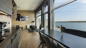 A modern kitchen with a large window overlooking a body of water.