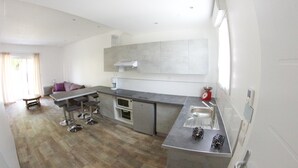 Una cocina moderna con una isla central, horno empotrado y electrodomésticos de acero inoxidable.