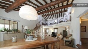 A spacious living area with a wooden dining table, benches, and a staircase leading to an upper level. - House Gordes. Classified 4☆ tourism (Gordes)