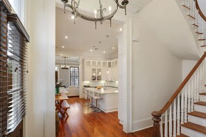 Enjoy a modern space with a kitchen, dining area, and staircase leading to an upper level.