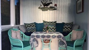 Ein gemütliches Zimmer mit einem blaugrünen Sofagarnitur, einer gemusterten Tischdecke und einer Wanddekoration.