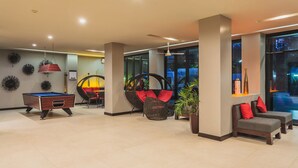 A modern lobby with a pool table, comfortable seating, and large windows. - Condo in Bangtao in Kris Condo - Unit402 (Choeng Thale)