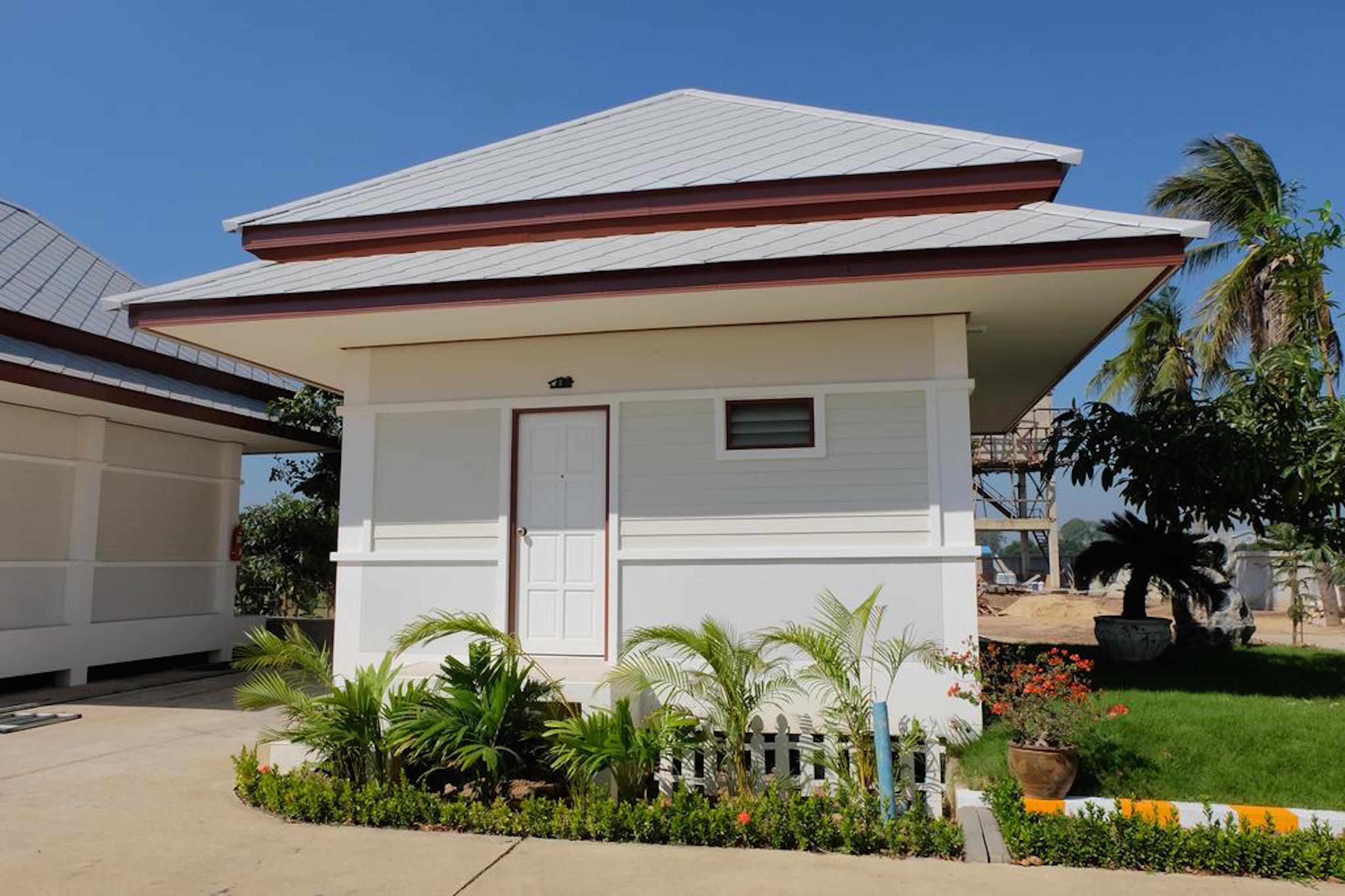 A single-story house with a white exterior, a front door, and a small window.