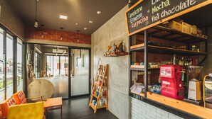 A coffee shop interior with seating, a coffee machine, and a menu board. - Condo in Karon in Chic Condo - Unit A609 (Karon)