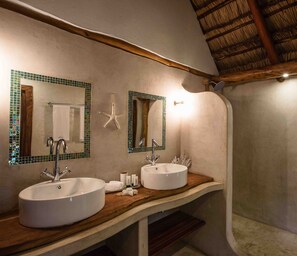 Bathroom features two sinks, a starfish decoration, and a sloped ceiling with exposed beams.