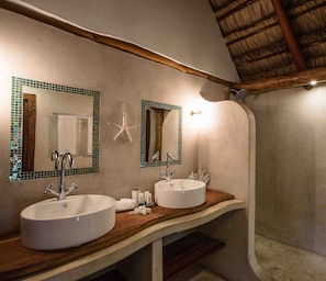 Bathroom features two sinks, a starfish decoration, and a sloped ceiling with exposed beams.