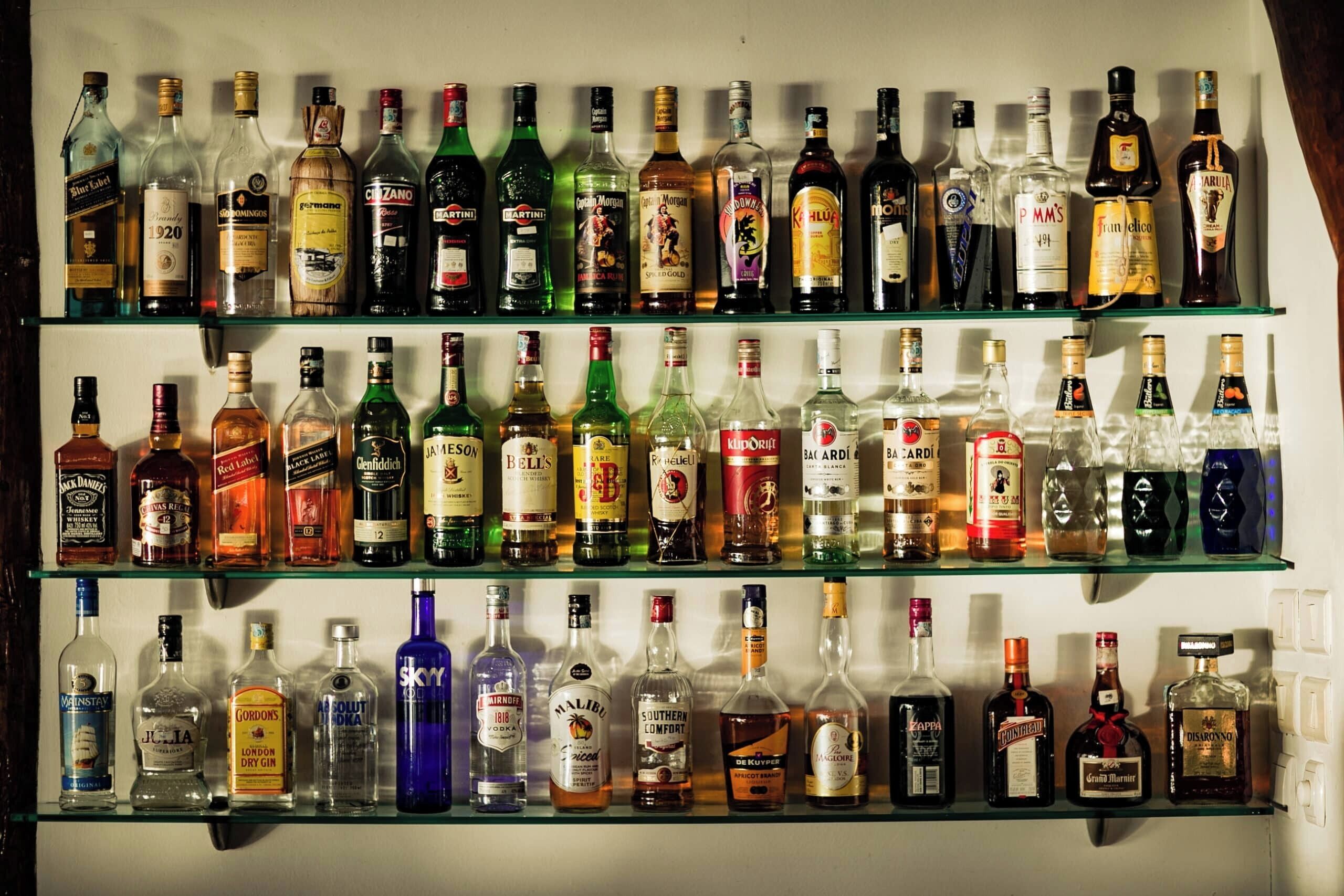 A wall of various liquor bottles on shelves.