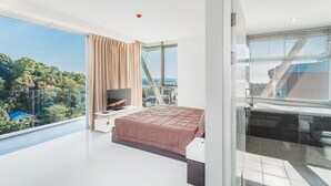 A modern bedroom with a large bed, a TV, and a balcony with a city view. - Condo in Karon in Chic Condo - Unit B708 (Karon)