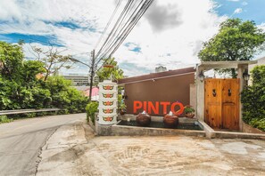 A building with a large sign reading "PINTO" and a wooden door. - Condo in Karon in Chic Condo - Unit B708 (Karon)