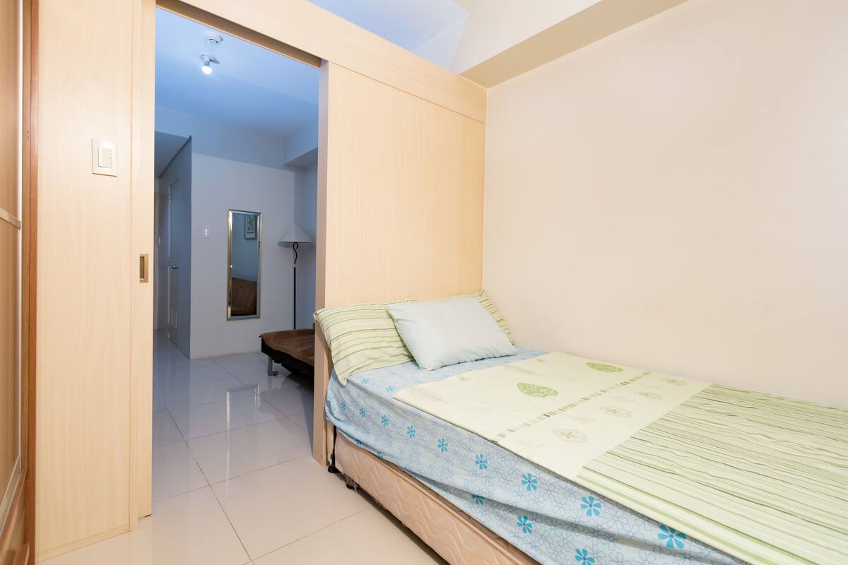 Une chambre à coucher avec un lit, une porte en bois et un miroir.