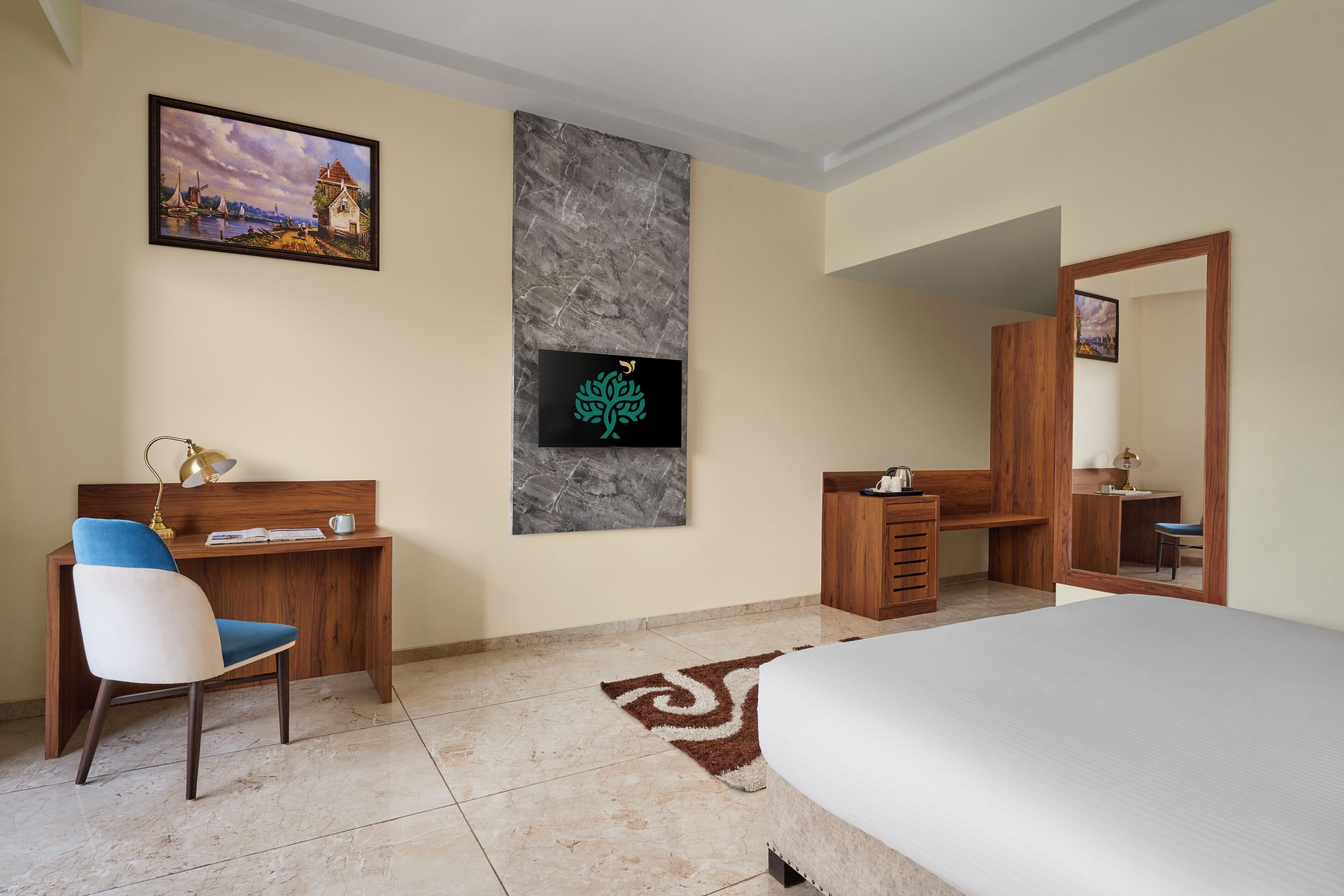 Una camera d'hotel con un letto, una scrivania con una sedia, un armadio in legno, uno specchio grande e un quadro appeso al muro.