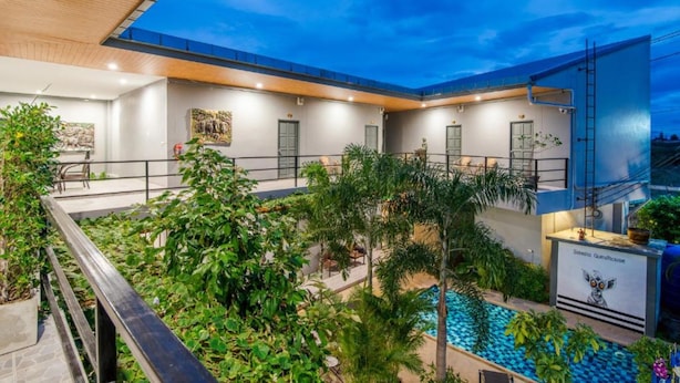 A modern hotel with a rooftop pool, indoor plants, and a clear view of the sky. - Samsha Guesthouse (Hua Hin)