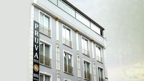 Un immeuble à plusieurs étages sur lequel on peut lire l’inscription : « PRUVA, hôtel, restaurant et café de prestige ».