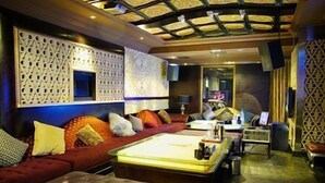 A hotel room with a sofa, a bed, a coffee table, and a TV.