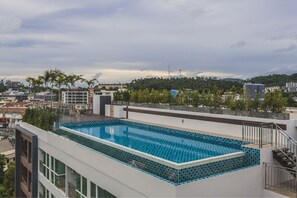 Outdoor pool, a rooftop pool, pool umbrellas, pool loungers