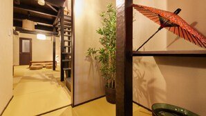 Ein traditionelles japanisches Interieur mit Tatami-Böden, einer Bambuspflanze und einem dekorativen Fächer.