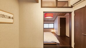 Ein Hotelzimmer mit Bett, Holzboden, Tür und Fenster mit Blick.