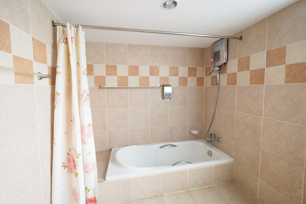Un baño con bañera, ducha y un perchero para toallas.