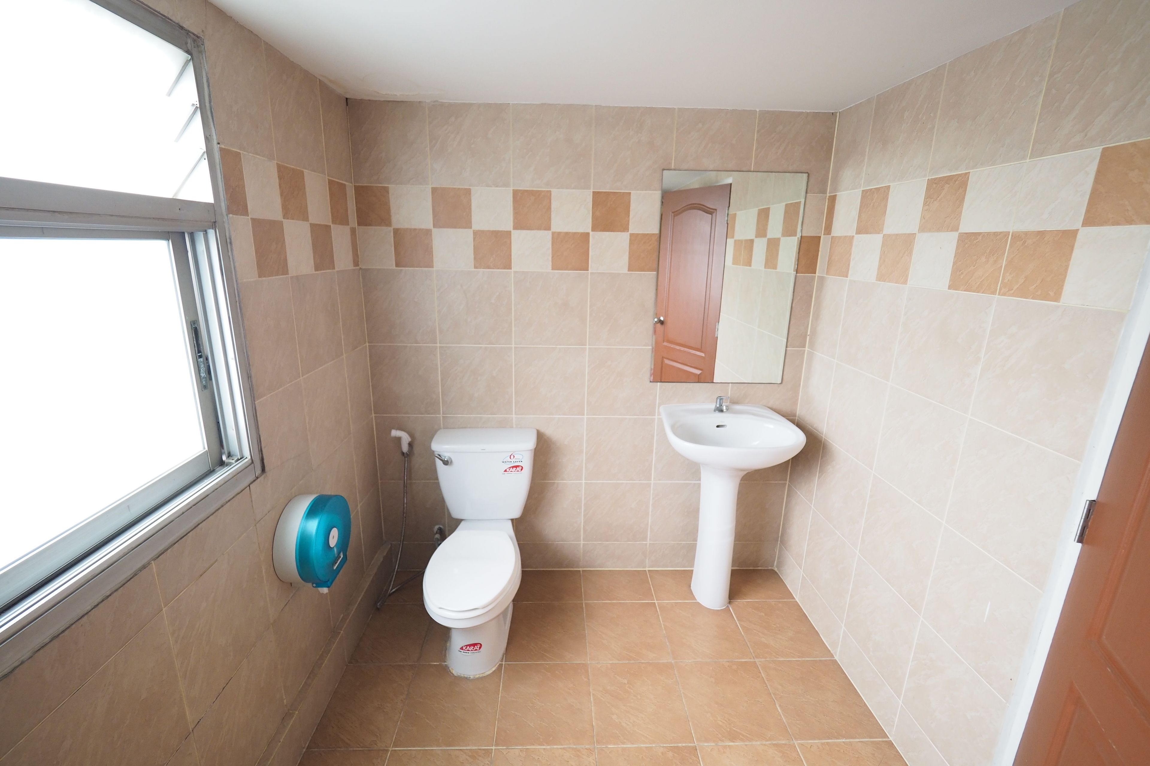A small bathroom with a toilet, sink, and window.