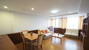 A modern living room with a dining area, a sofa set, and a television. - Navanakorn Golden View (Khlong Luang)
