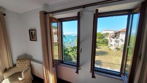 Una habitación con un ventanal grande, una silla y un radiador.