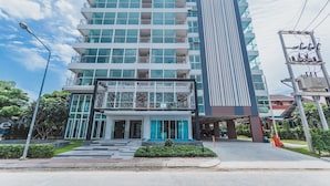 Et moderne hotel med flere etager, en markant indgang og parkeringsplads.