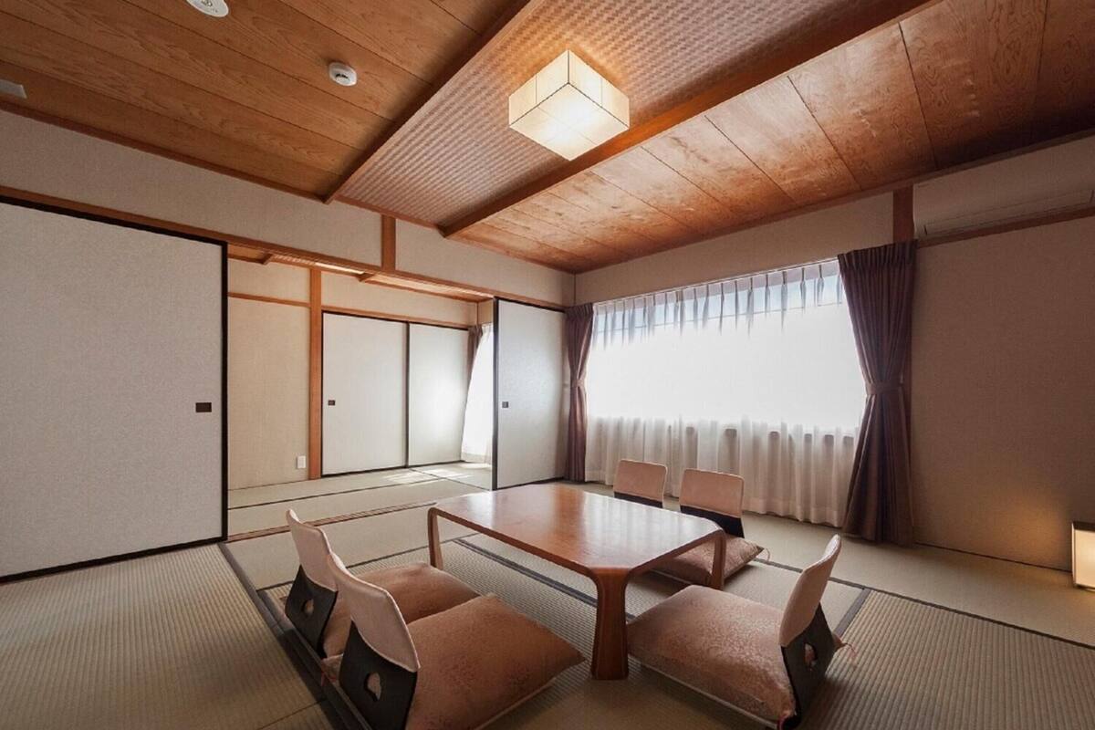 Ein traditioneller japanischer Raum mit Tatami-Böden, einem niedrigen Holztisch und Schiebetüren.