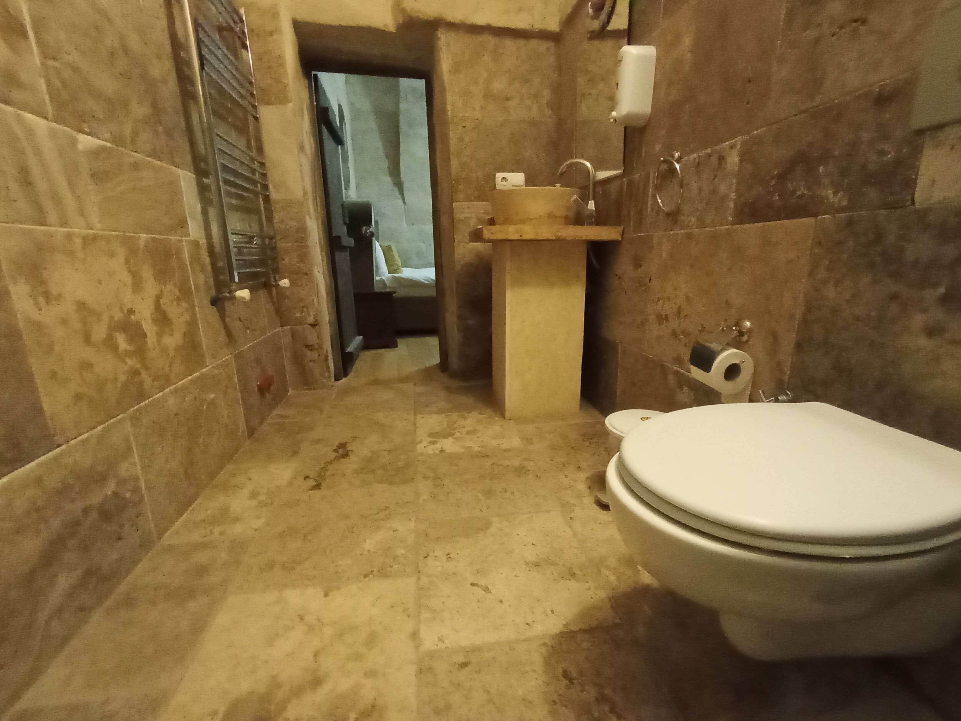 A bathroom with a toilet, sink, and shower area.