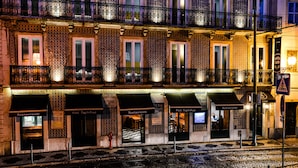 Een rij restaurants met terrasjes, een kinderafsluiting en een spoorlijn op de voorgrond.