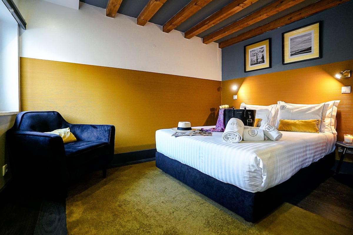 Ein Hotelzimmer mit Bett, Stuhl und Nachttisch.