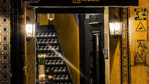 Een trap die leidt naar een barruimte, met een bord waarop 'Santa Luzia B&B' staat.