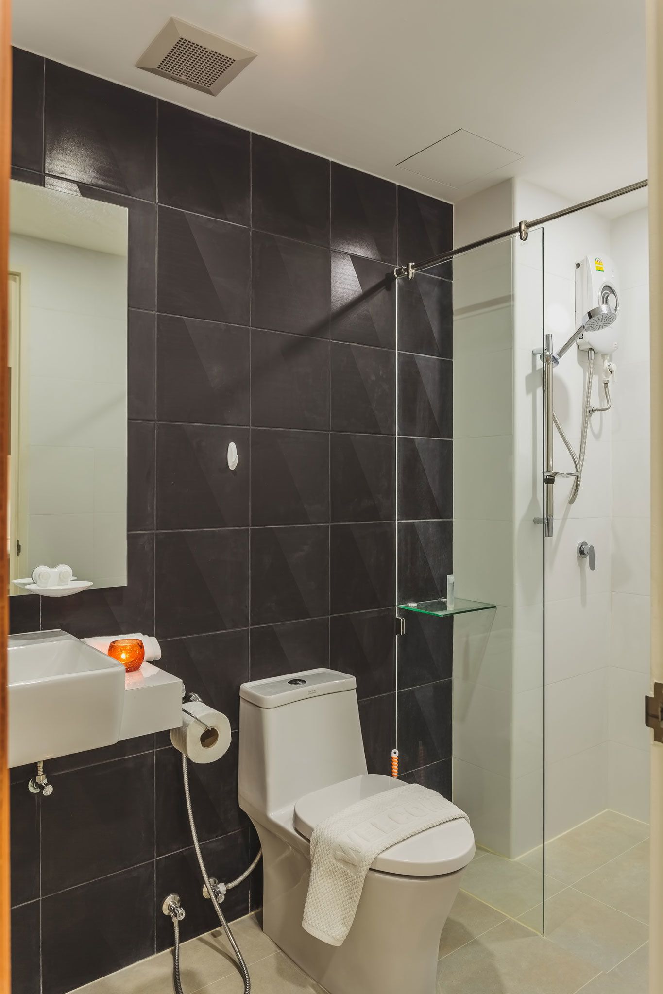 Ein modernes Badezimmer mit Toilette, Waschbecken und Duschkabine aus Glas.