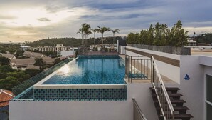 A rooftop swimming pool with a view of the surrounding area, including palm trees and buildings. - Condo in Kata in Ozone - A604 (Karon)