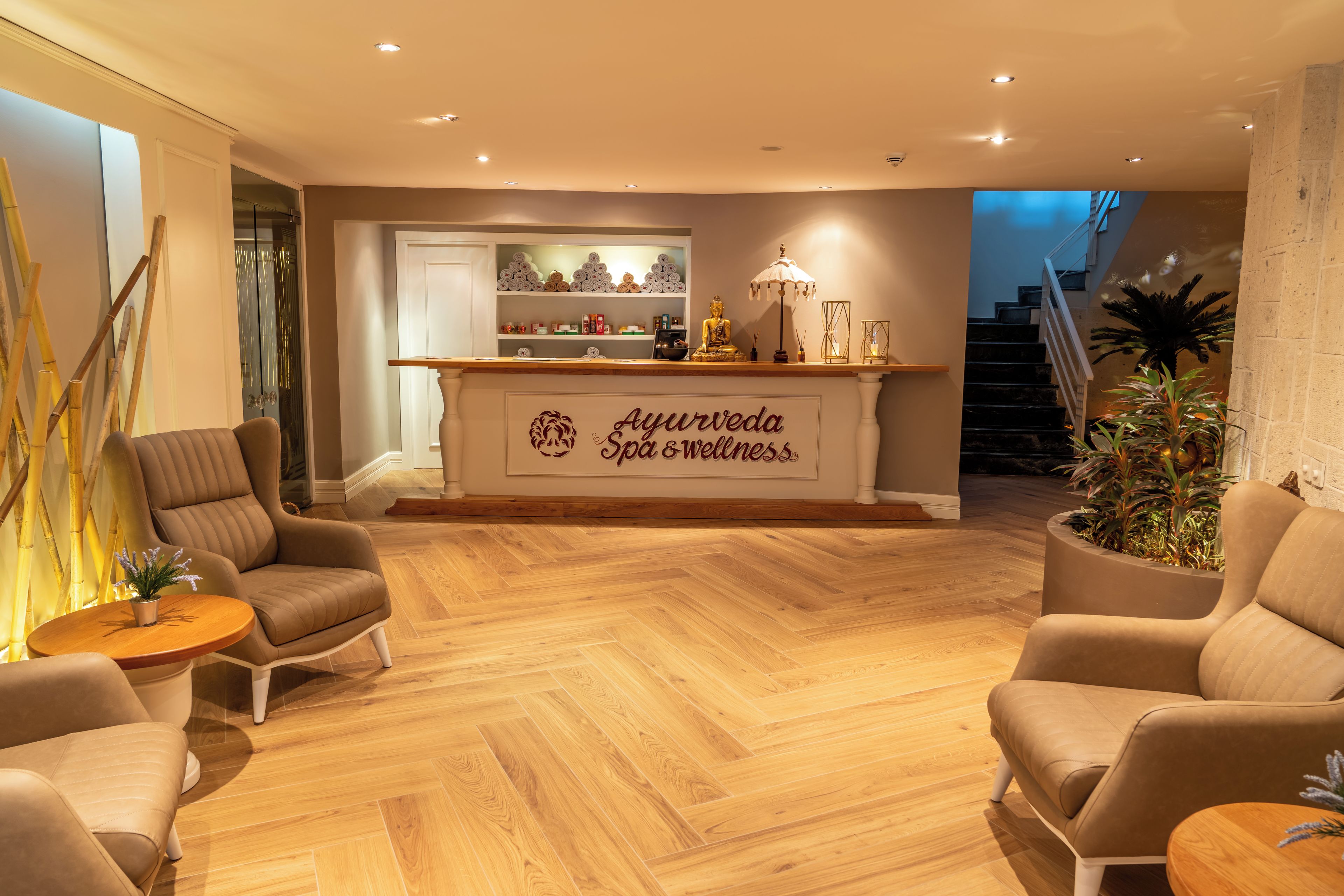A spa area with a reception desk, seating, and a staircase.