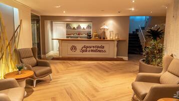 A spa area with a reception desk, seating, and a staircase.