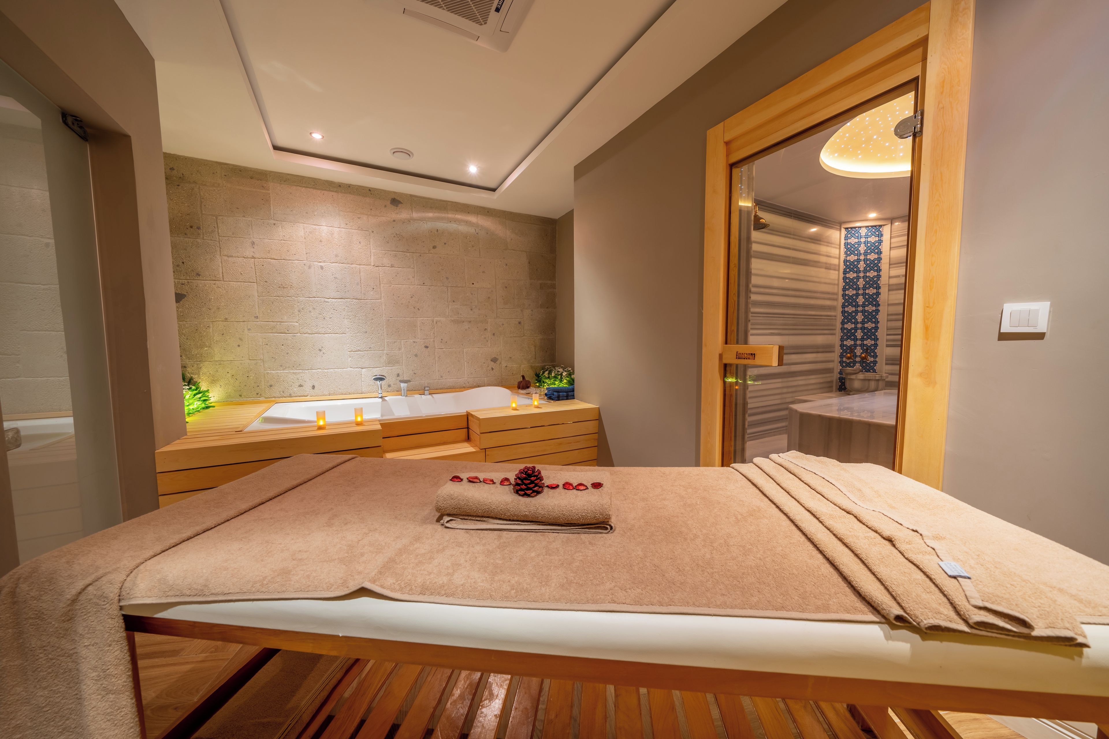 Un baño moderno con una banca de madera, un espejo grande y una bañera.