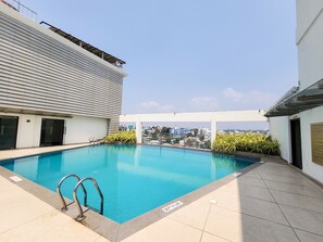 A rooftop swimming pool with clear blue water, surrounded by tiled flooring and metal railings. - Dimora Thiruvananthapuram (Thiruvananthapuram)