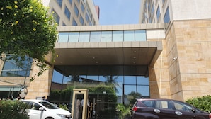 Um edifício moderno com entrada de vidro e uma cobertura.