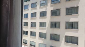 A multi-story building with numerous windows, some with curtains.