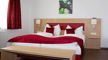 A hotel room with a bed, bedside tables, a bench, and a painting on the wall.